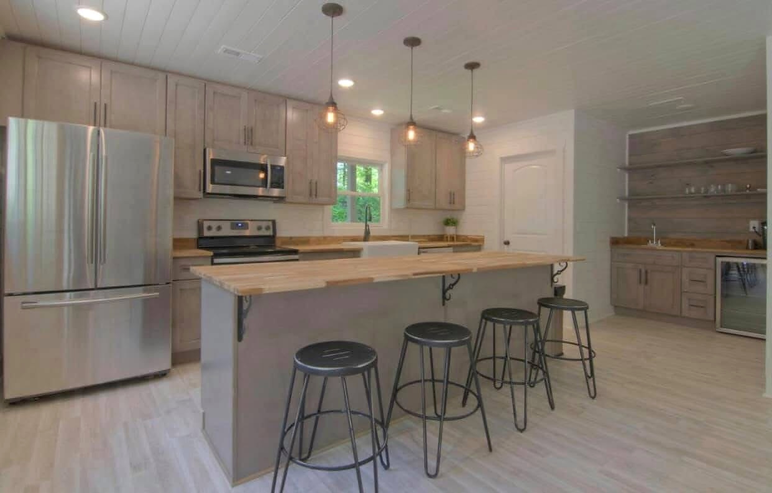 Real open concept living room connecting to remodeled kitchen with wood island