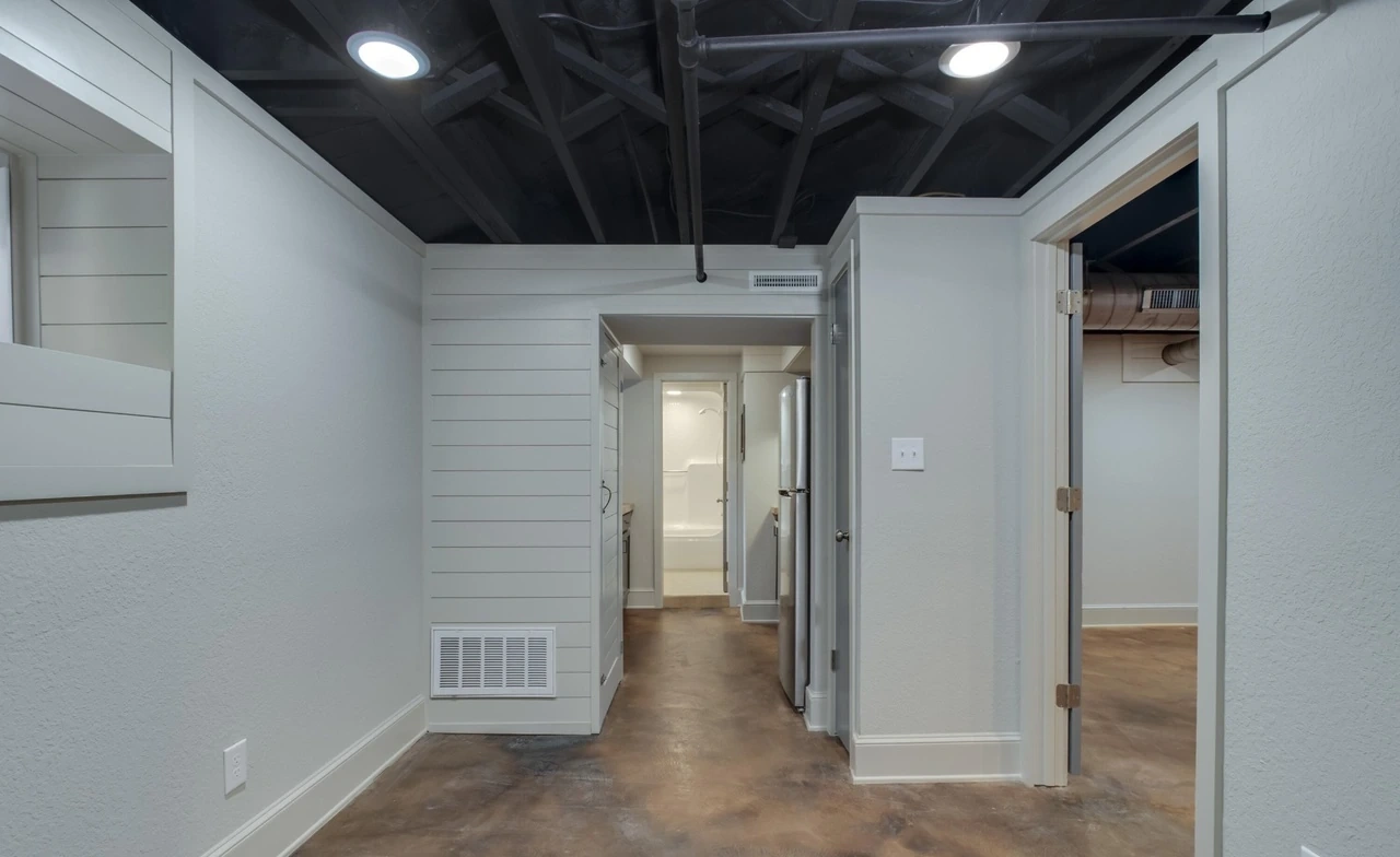 Downstairs room with exposed ceiling and wood-look flooring