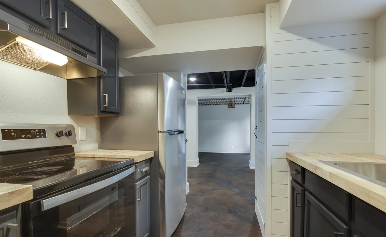 Downstairs kitchen with dark cabinets and stainless appliances