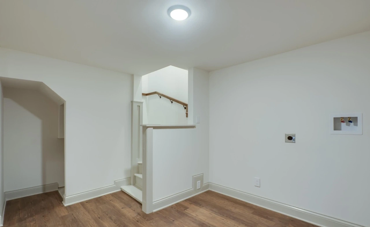 Downstairs interior with white walls and wood-look flooring