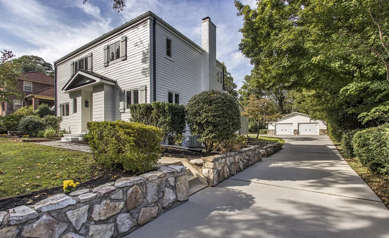 House exterior with driveway and stone retaining wall