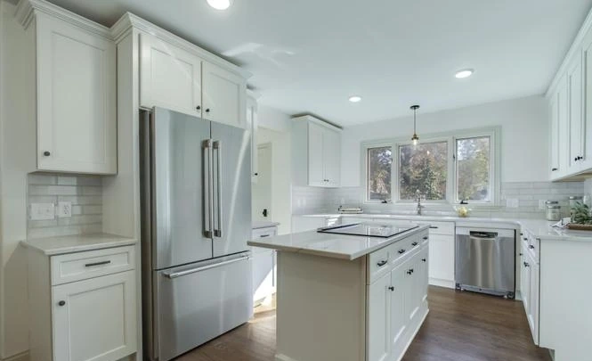 Kitchen with white cabinets and stainless refrigerator