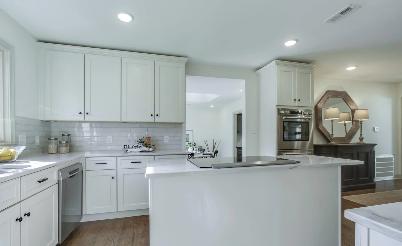 White kitchen cabinets, stone counters and peninsula